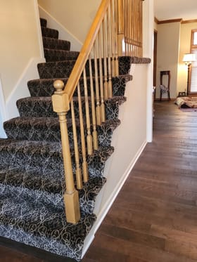 Hardwood staircase with a patterned runner