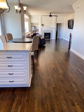 Red oak floor refinished in a provincial stain in an open kitchen