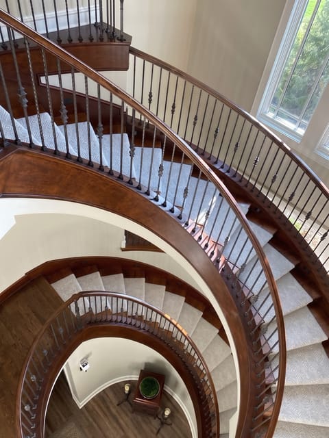 Curved hardwood staircase with a runner in a Kansas City metro home