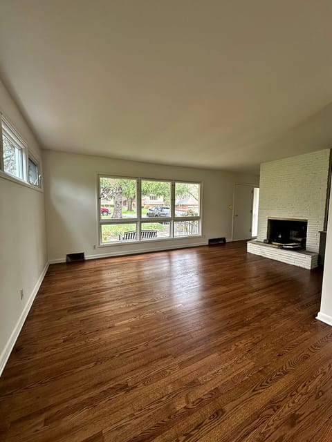 Refinished hardwood floor in the living room of a 70-year-old home