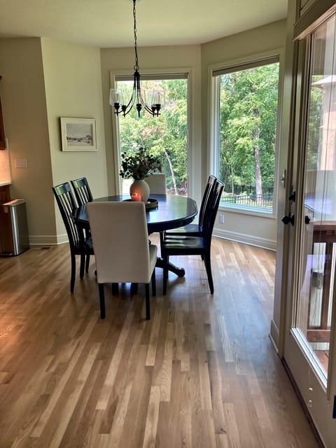 Refinished hardwood floor in a dining room with a bay window