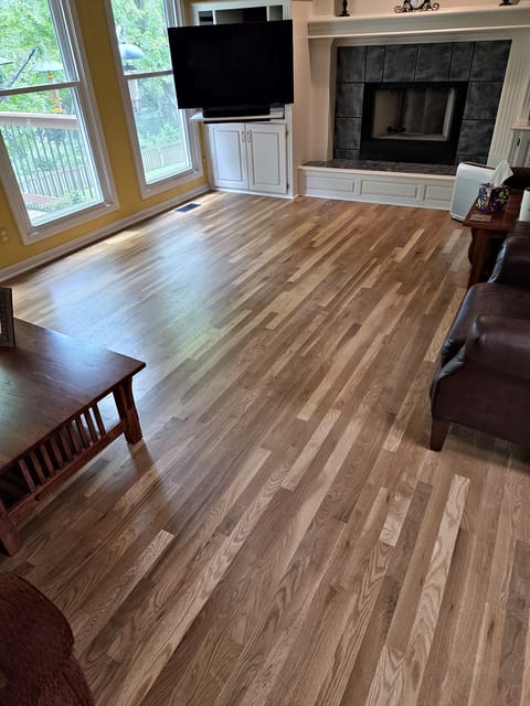 New white oak boards woven into an existing white oak floor in a living room