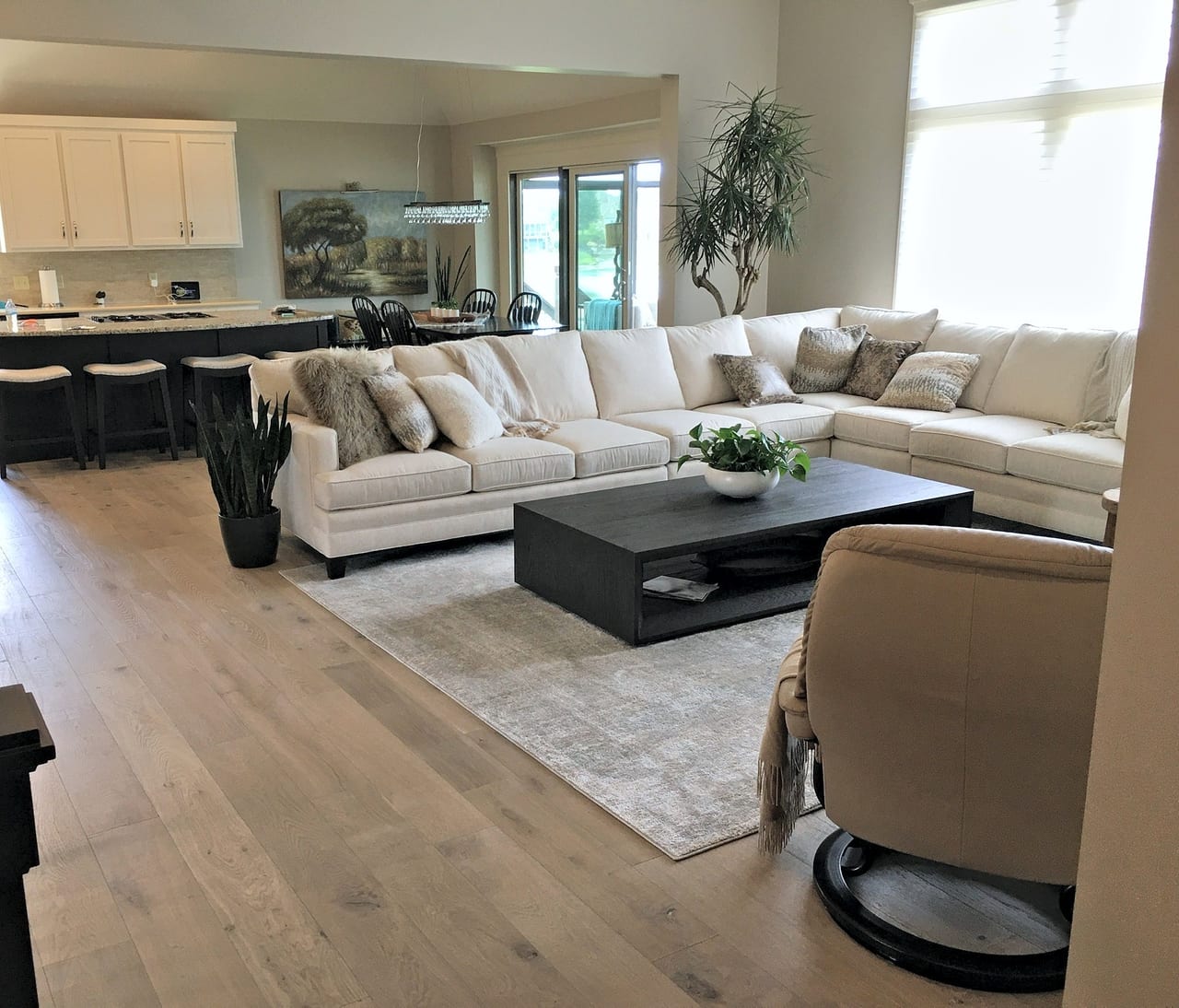 Wide-plank light oak flooring running through an open-plan living room and kitchen in a Kansas City metro home